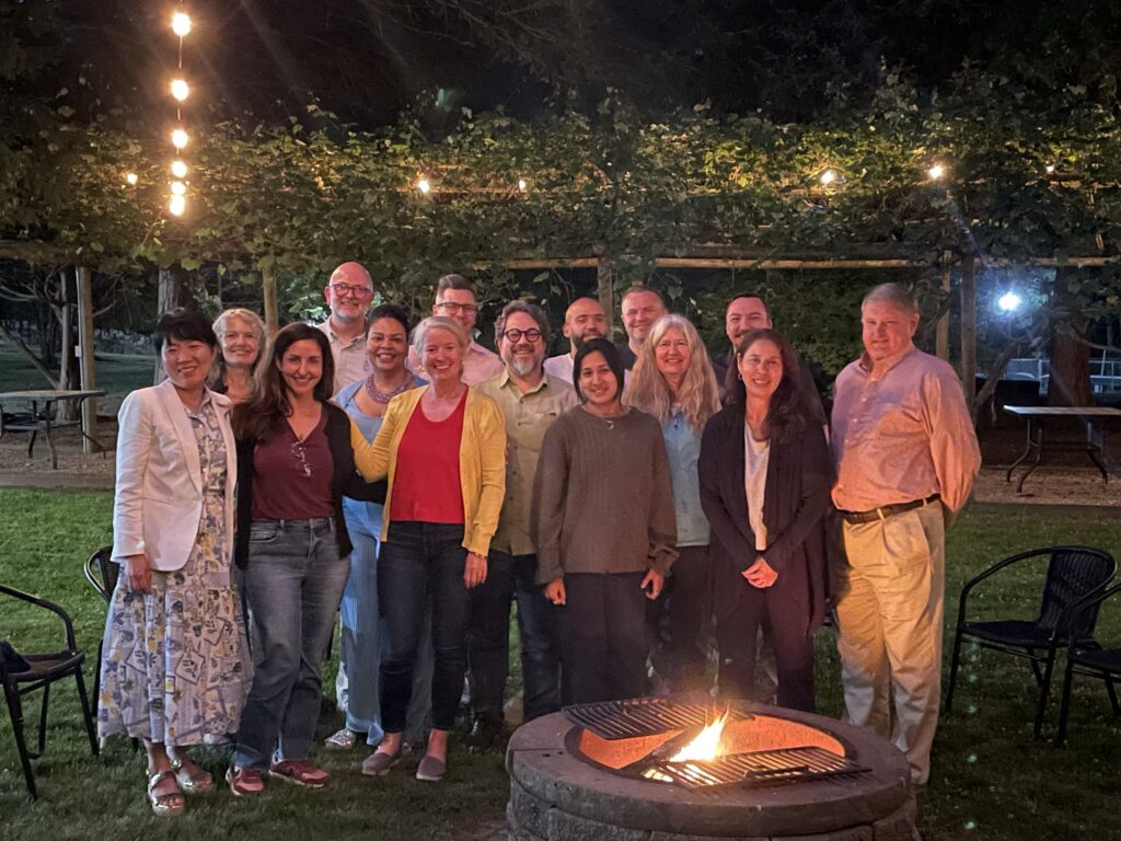 Social workers stand around a firepit.