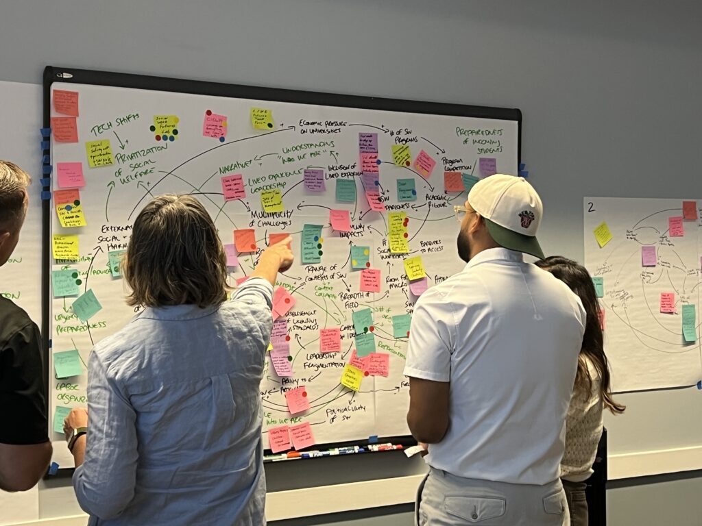 Social workers have a discussion around a white board.